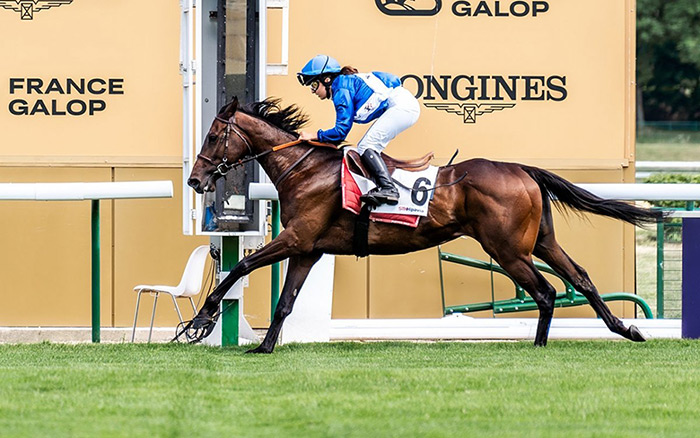 Capucine sur son cheval au galop passe la cellule d'arrivée
