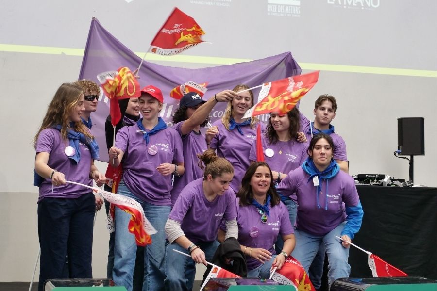 Les 11 étudiants lasalliens, vêtus de leur t-shirt violet représentant UniLaSalle Rouen, et des drapeaux normands dans les mains, prennent la pose d'équipe